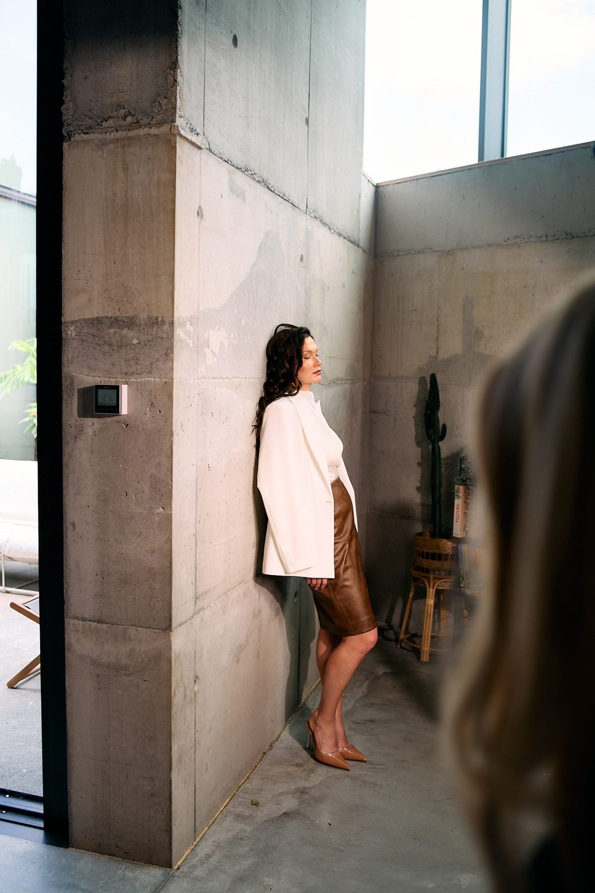 Model in the BOLDNSUBTLE oversized white blazer against a concrete wall, from the Autumn / Winter 2026 campaign