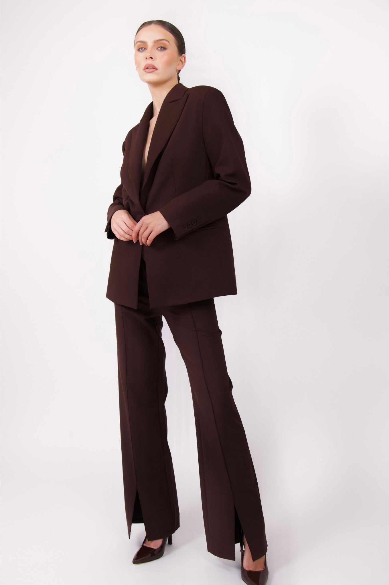 BOLDNSUBTLE’s fitted brown tailored trousers with precise tailoring and front slits, offering effortless movement and a contemporary, polished aesthetic.