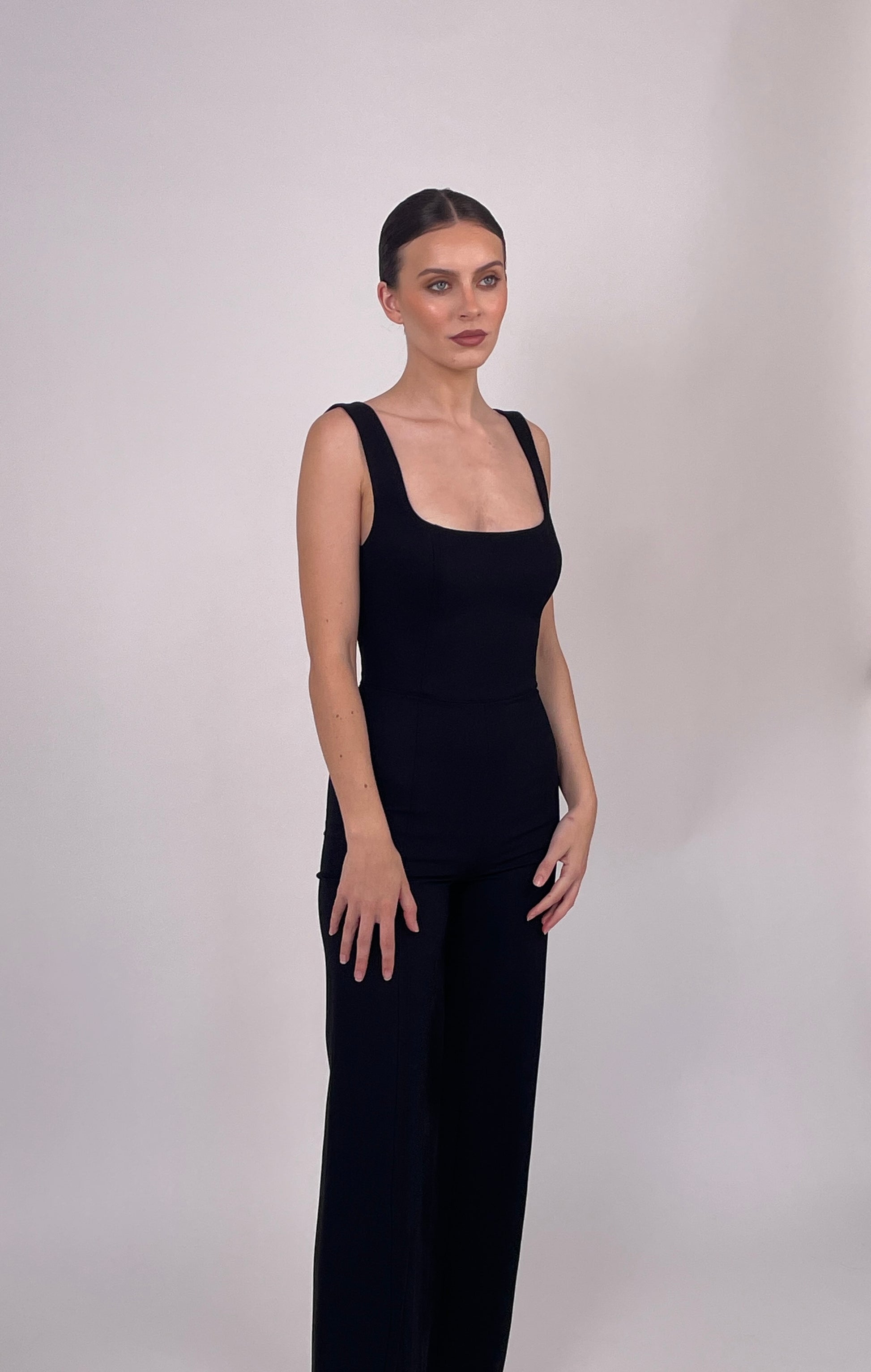 BOLDNSUBTLE black fitted jumpsuit – structured minimalist tailoring with a shaped neckline and low-back design. A capsule wardrobe essential.