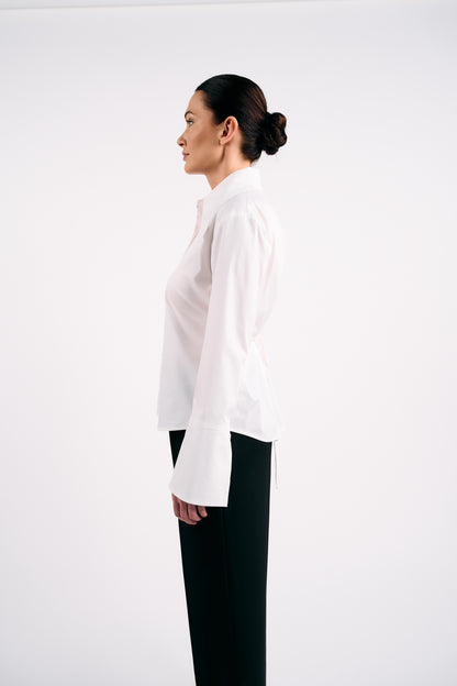 Woman wearing a white blouse and black trousers on a white background
