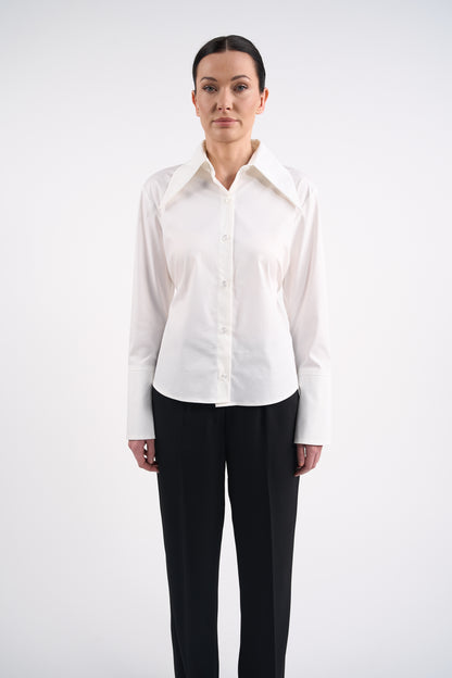 Woman wearing a white blouse and black trousers on a white background